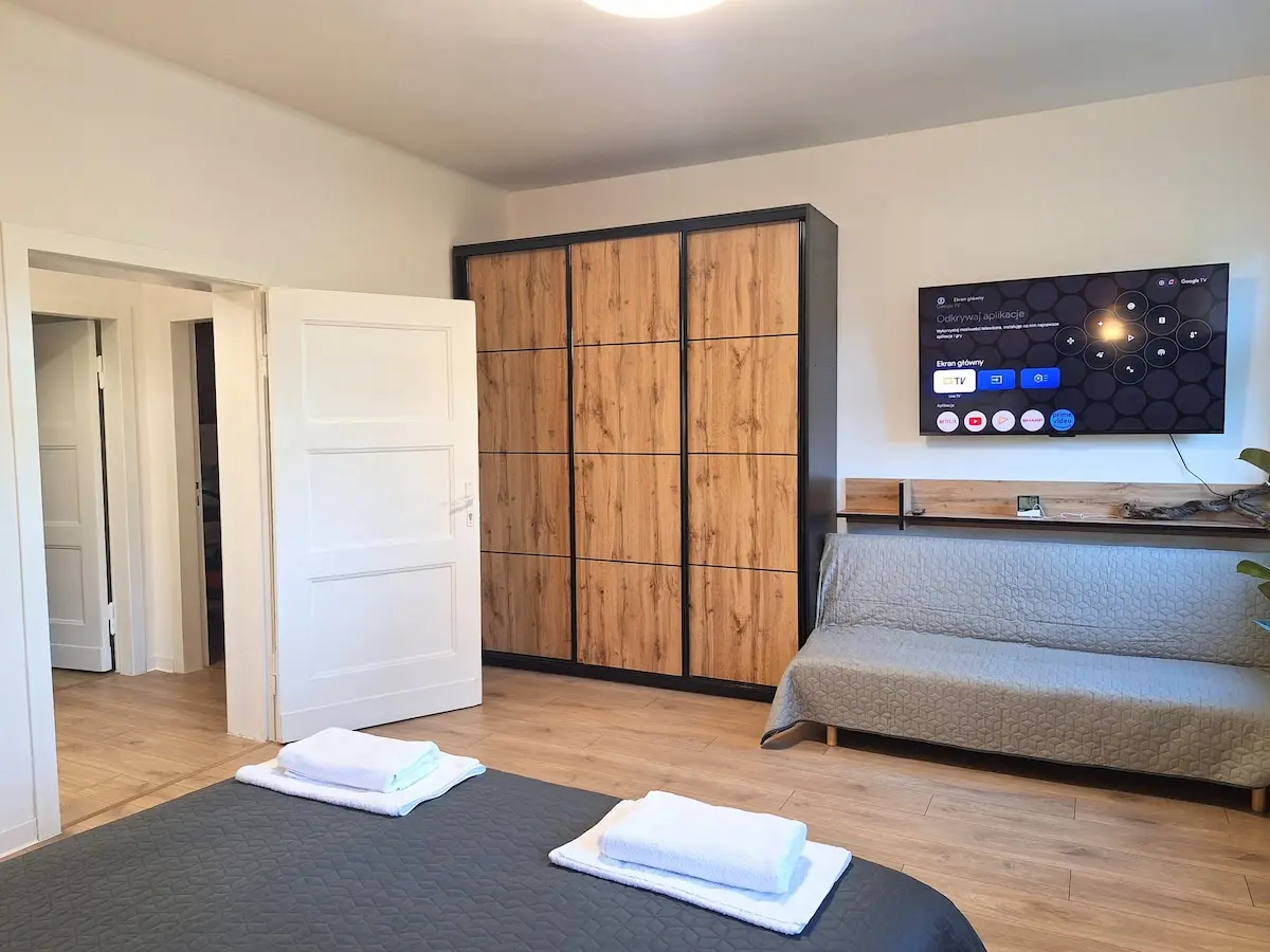 Sypialnia z szafą, smart TV i sofą