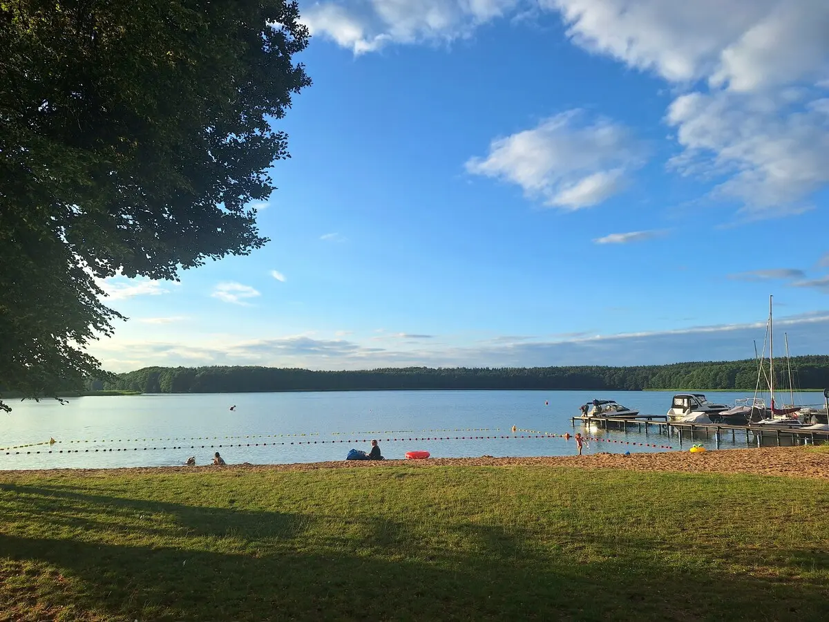 Plaża nad jeziorem i przystań w słoneczny dzień