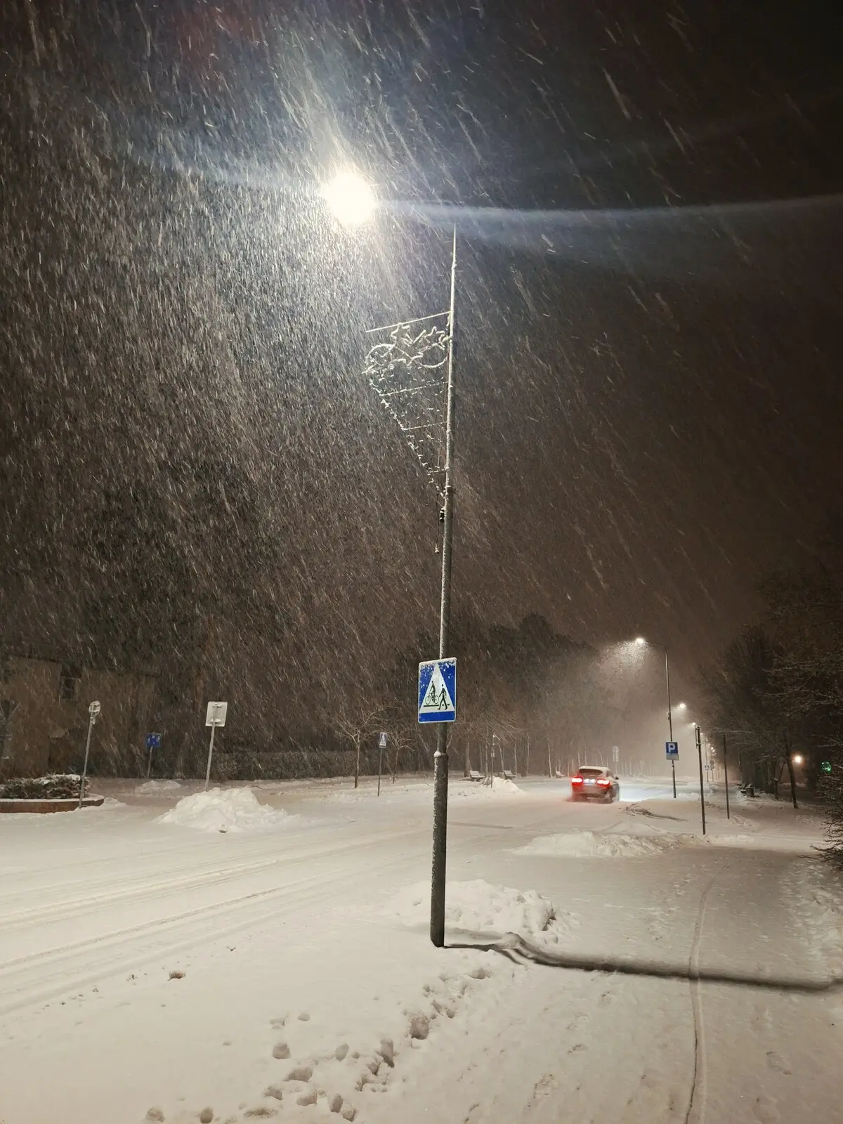 Śnieżyca na ulicy miasteczka nocą